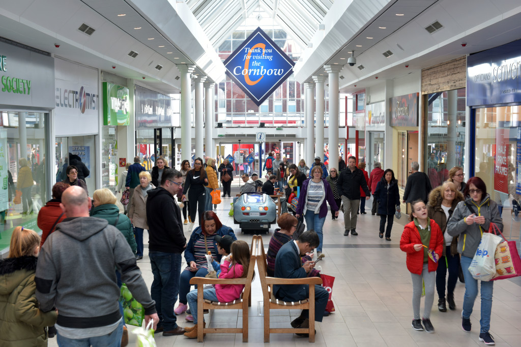 Inside the Cornbow shopping centre with people shopping and walking through the centre.